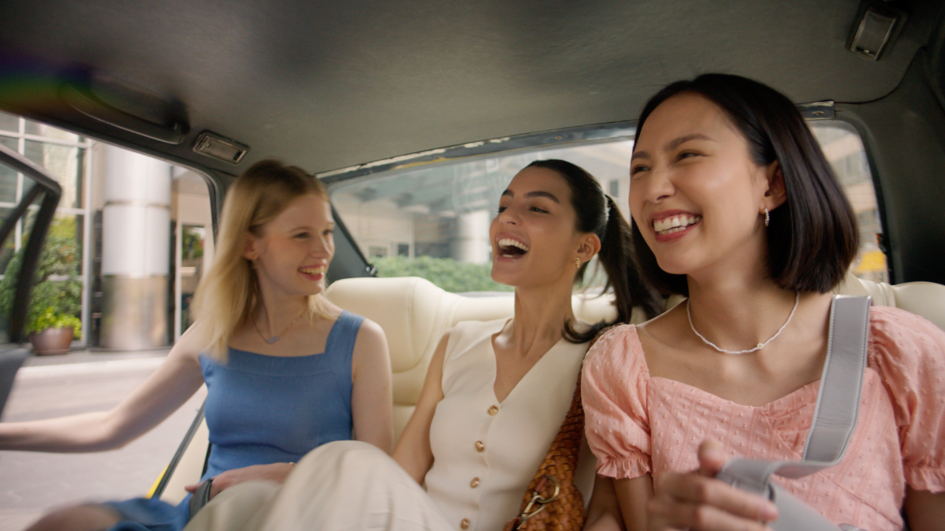 Friends laughing in the bac of a car