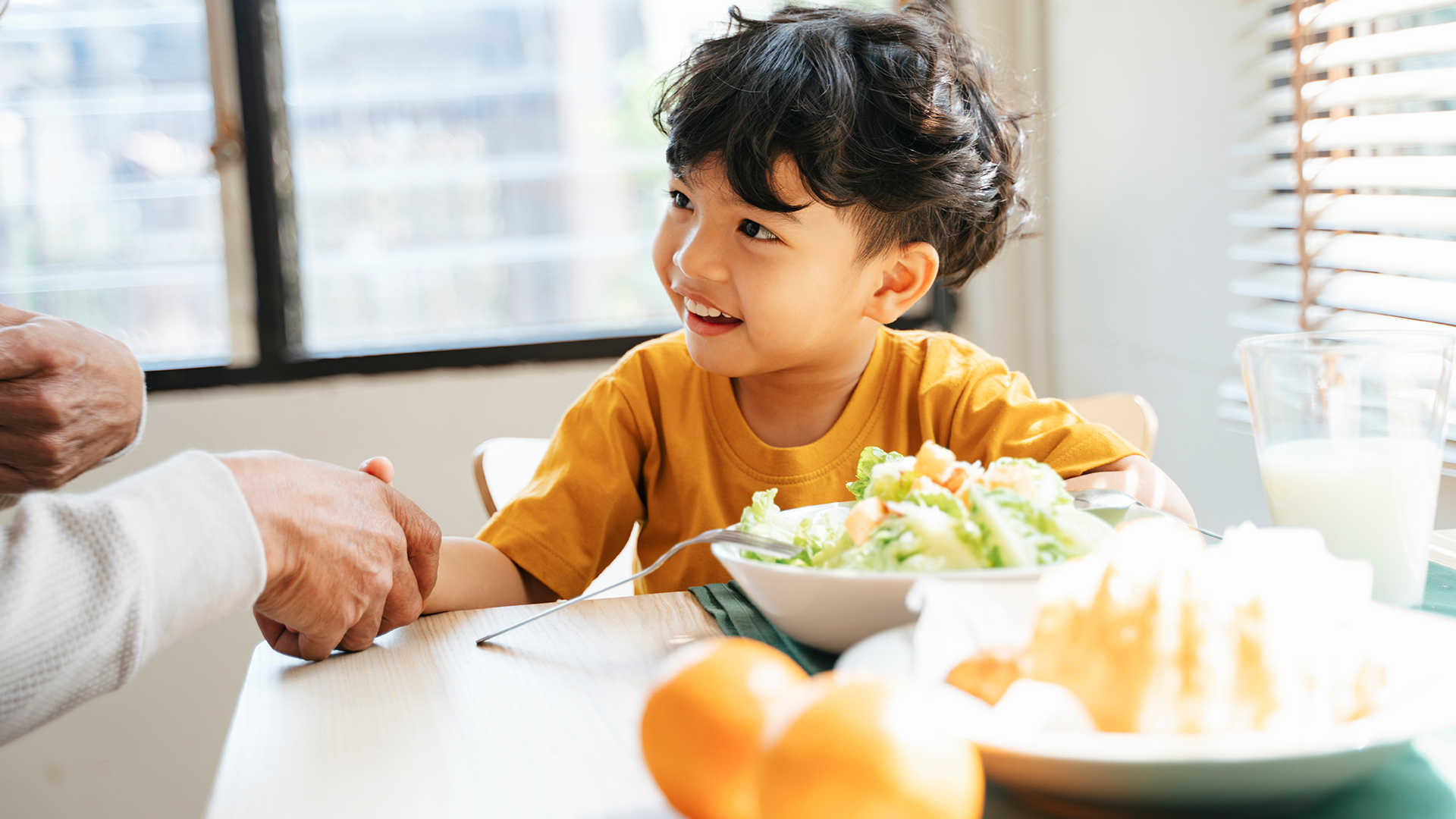 Child eating lunch shaking hands
