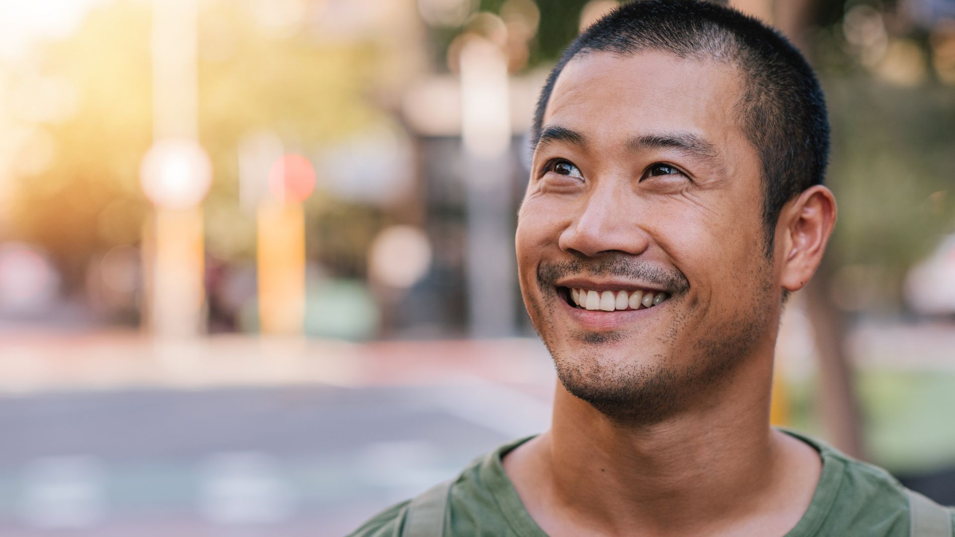 Smiling person outdoors on a sunny day.